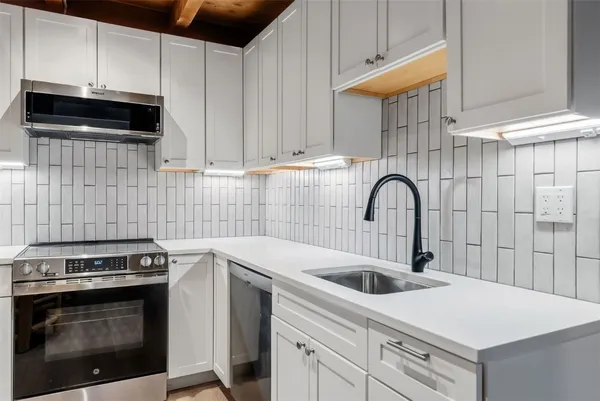 a kitchen with a sink stove and cabinets