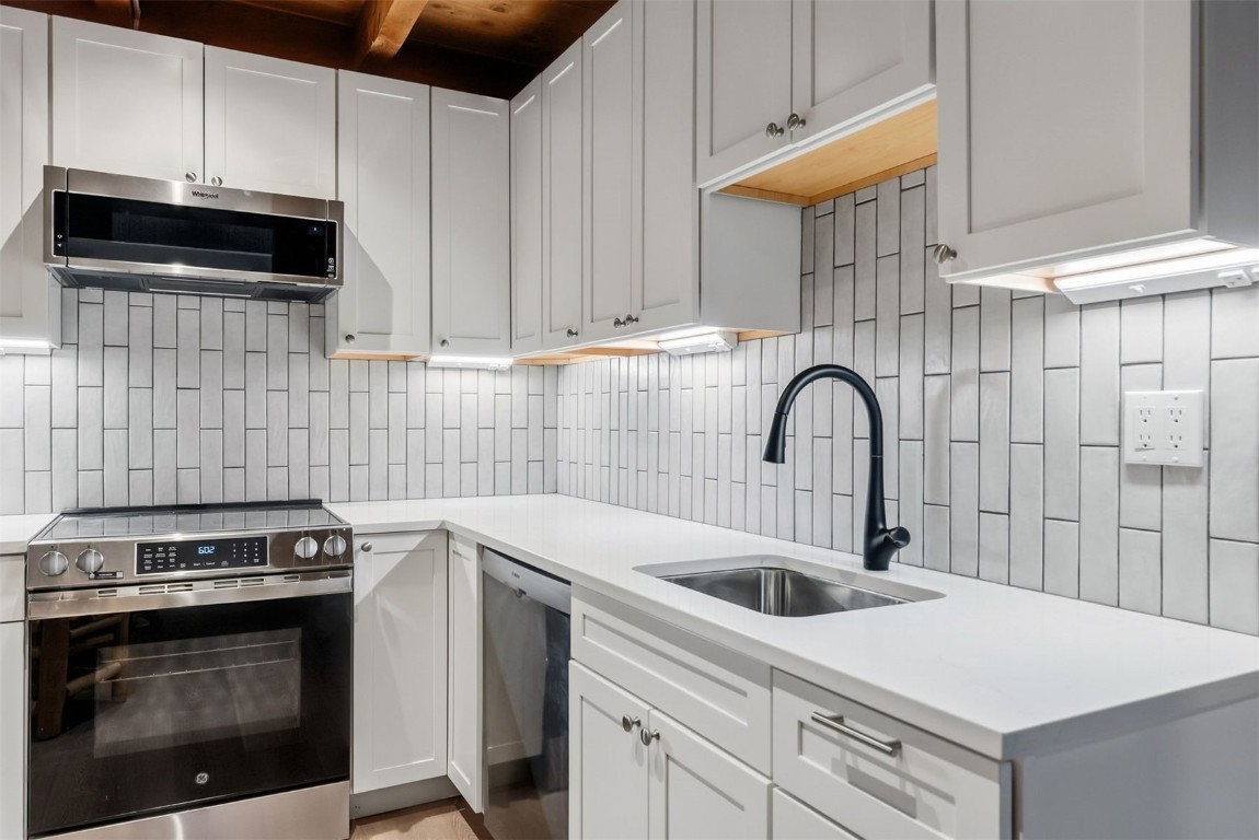 4200 Lodgepole Circle, Unit 306 Silverthorne, CO 80498 - Photo 4 of 26 a kitchen with a sink stove and cabinets