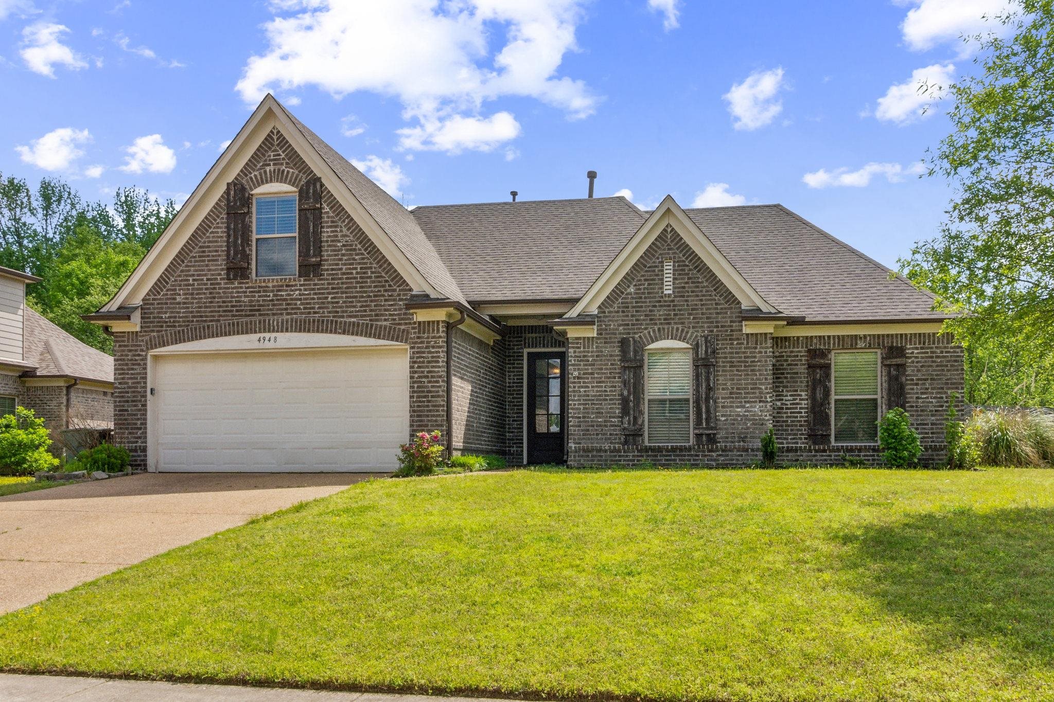 a front view of a house with yard and garage