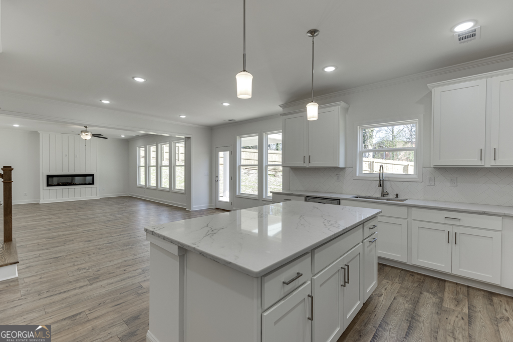 929 Lakeview Drive Commerce, GA 30529 - Photo 12 of 44 a kitchen with center island a sink dishwasher a stove and a refrigerator with wooden floor