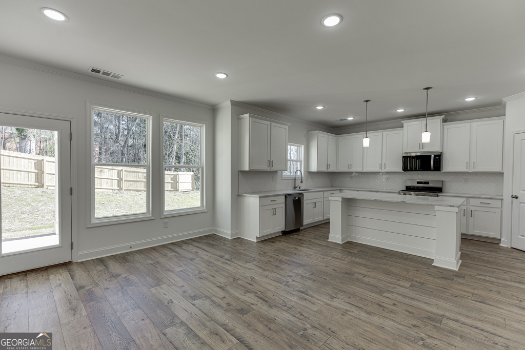 929 Lakeview Drive Commerce, GA 30529 - Photo 14 of 44 a large kitchen with stainless steel appliances granite countertop a stove a sink dishwasher and a white countertops with wooden floor
