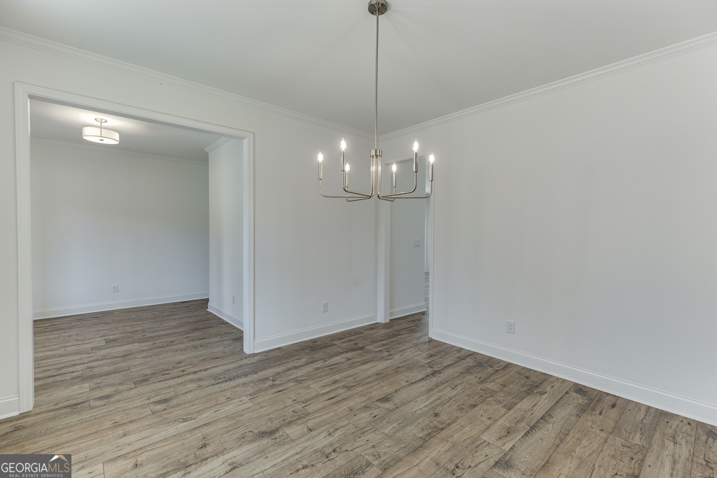 929 Lakeview Drive Commerce, GA 30529 - Photo 6 of 44 a view of an empty room with wooden floor and kitchen view