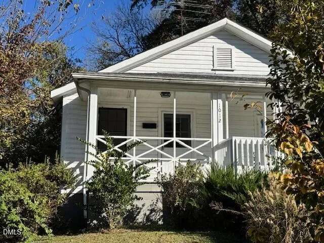 a view of house with yard and outdoor seating