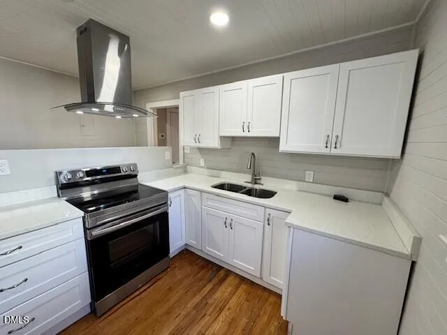 a view of a refrigerator in kitchen and an empty room in wooden floor