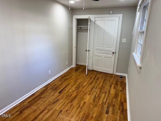 1012 Berkeley Street Durham, NC 27705 - Photo 10 of 12 an empty room with wooden floor and closet