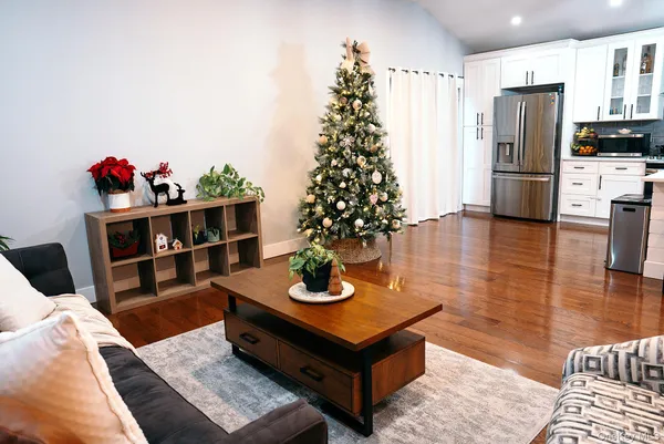 a living room with furniture potted plant and kitchen view