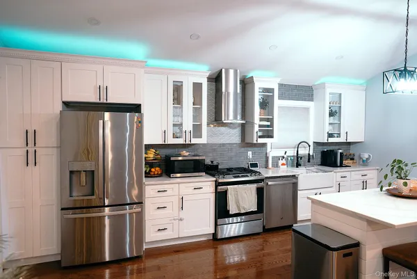a kitchen with white cabinets and stainless steel appliances
