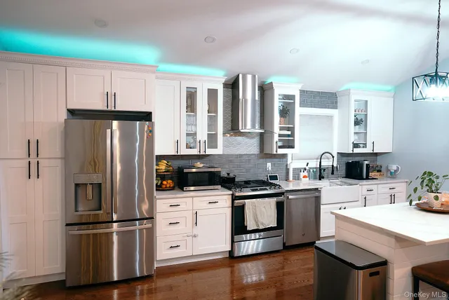 a kitchen with white cabinets and stainless steel appliances