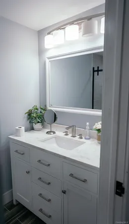 a bathroom with a granite countertop sink and a mirror