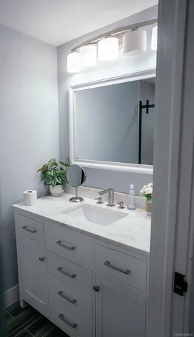 a bathroom with a granite countertop sink and a mirror