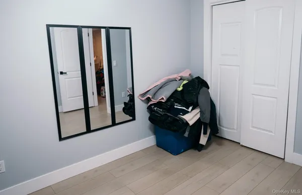 an empty room with wooden floor and hallway