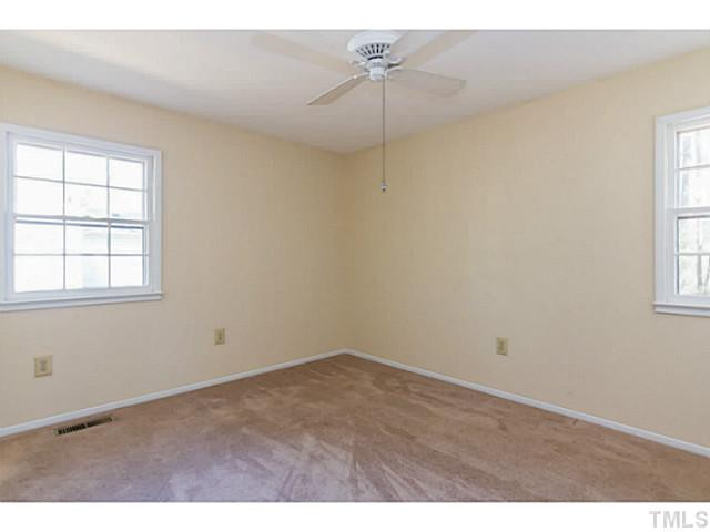 1317 Clermont Road Durham, NC 27713 - Photo 15 of 25 an empty room with windows and chandelier fan