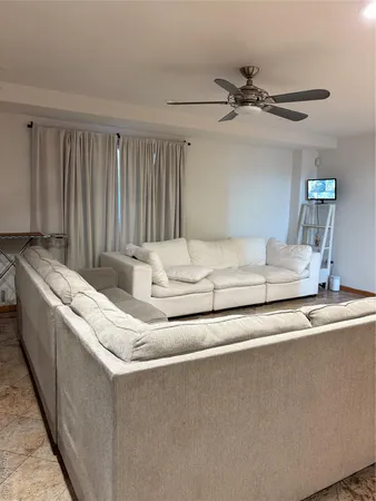 a living room with furniture and a ceiling fan