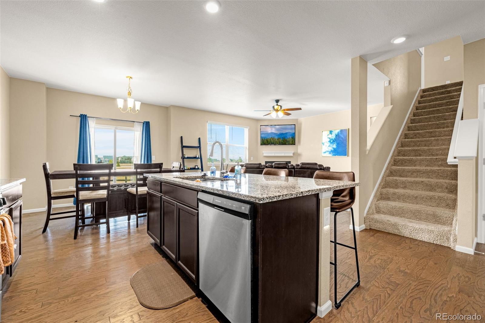 91 South Quantock Street Aurora, CO 80018 - Photo 15 of 45 a kitchen with kitchen island granite countertop a sink a counter top space and appliances