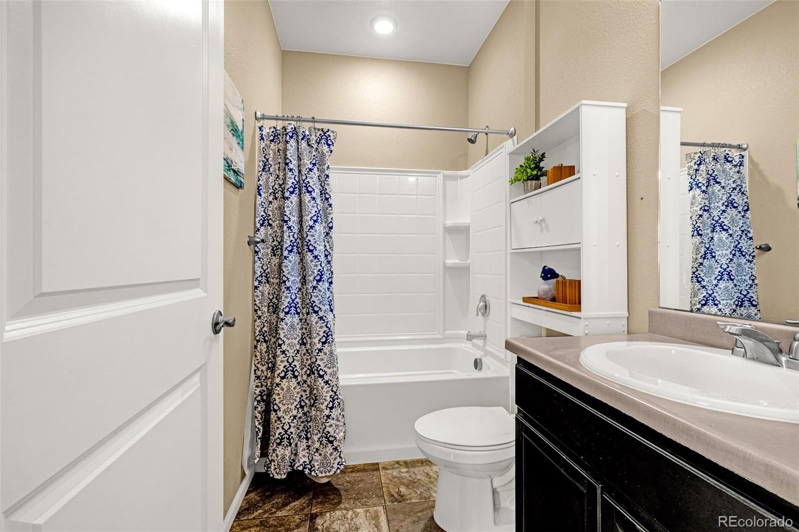 91 South Quantock Street Aurora, CO 80018 - Photo 20 of 45 a bathroom with a sink a toilet and shower curtain