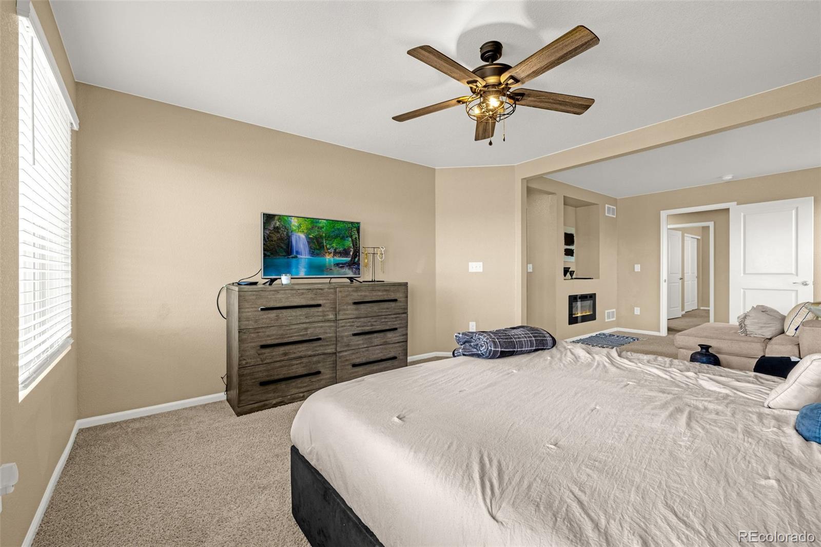 91 South Quantock Street Aurora, CO 80018 - Photo 25 of 45 a bedroom with a bed and a chandelier