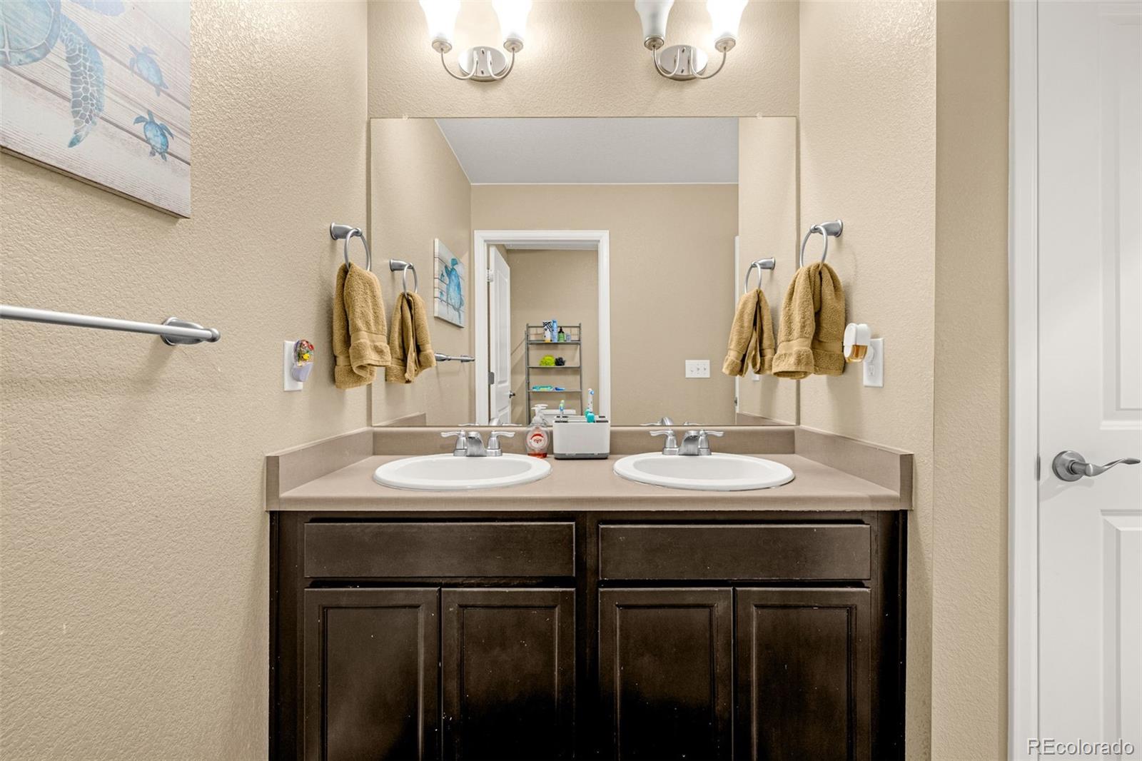 91 South Quantock Street Aurora, CO 80018 - Photo 33 of 45 a bathroom with a sink and a mirror