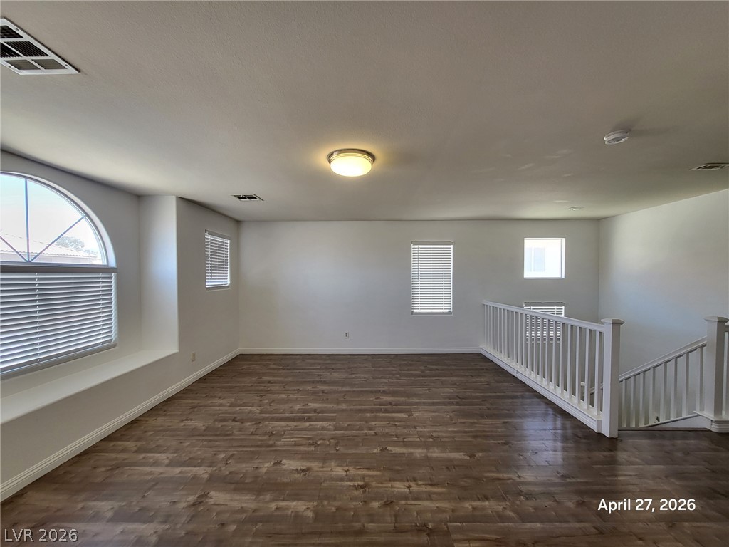 4548 Flaming Ridge Trail Las Vegas, NV 89147 - Photo 8 of 21 Rich wood-look flooring and multiple windows elevate this versatile upper-level loft area.