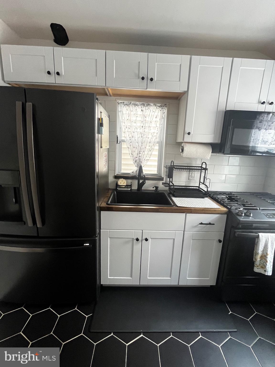 121 Mercy Street Philadelphia, PA 19148 - Photo 27 of 61 a kitchen with a sink a stove and cabinets