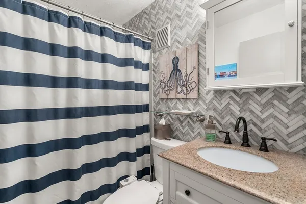 a bathroom with a granite countertop sink and a mirror