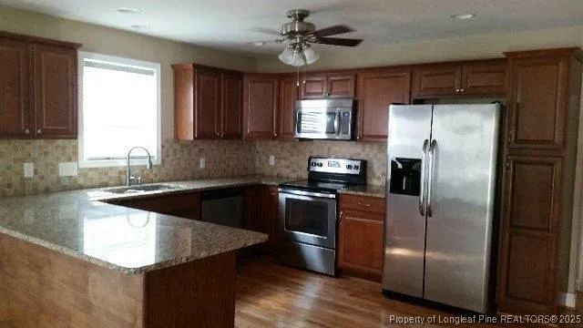 a kitchen with granite countertop a refrigerator a sink a stove and cabinets
