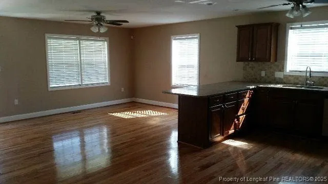 a kitchen with granite countertop wooden cabinets a sink and a window