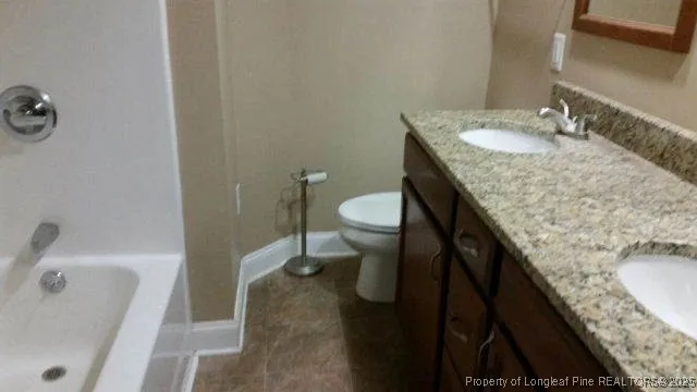 a bathroom with a granite countertop sink and toilet