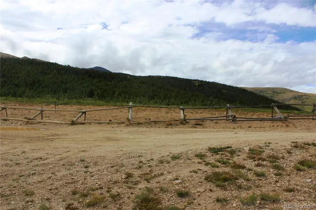 a view of a yard with wooden fence