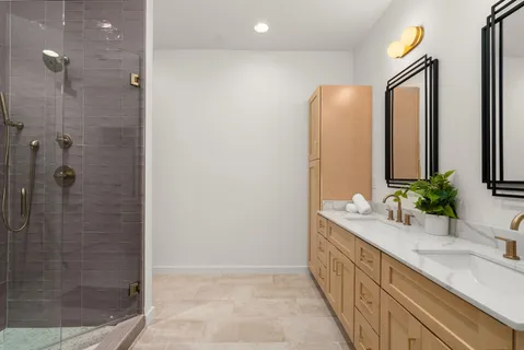 a bathroom with a granite countertop sink a mirror and a shower