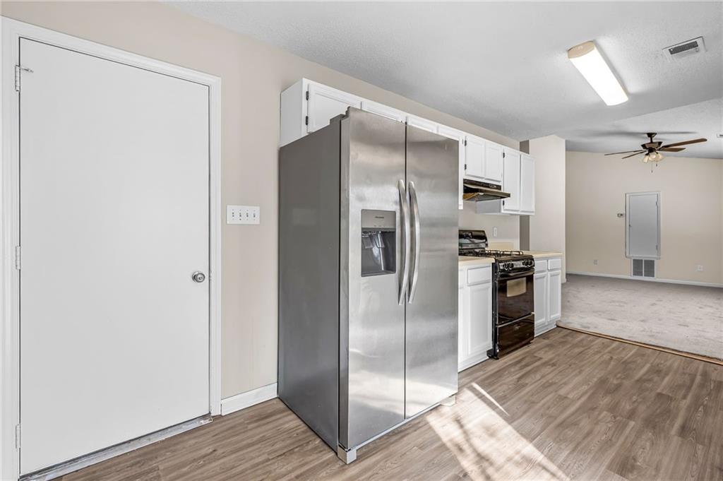 5345 Memorial Lane Southwest Powder Springs, GA 30127 - Photo 13 of 35 a kitchen with stainless steel appliances a refrigerator and wooden floor