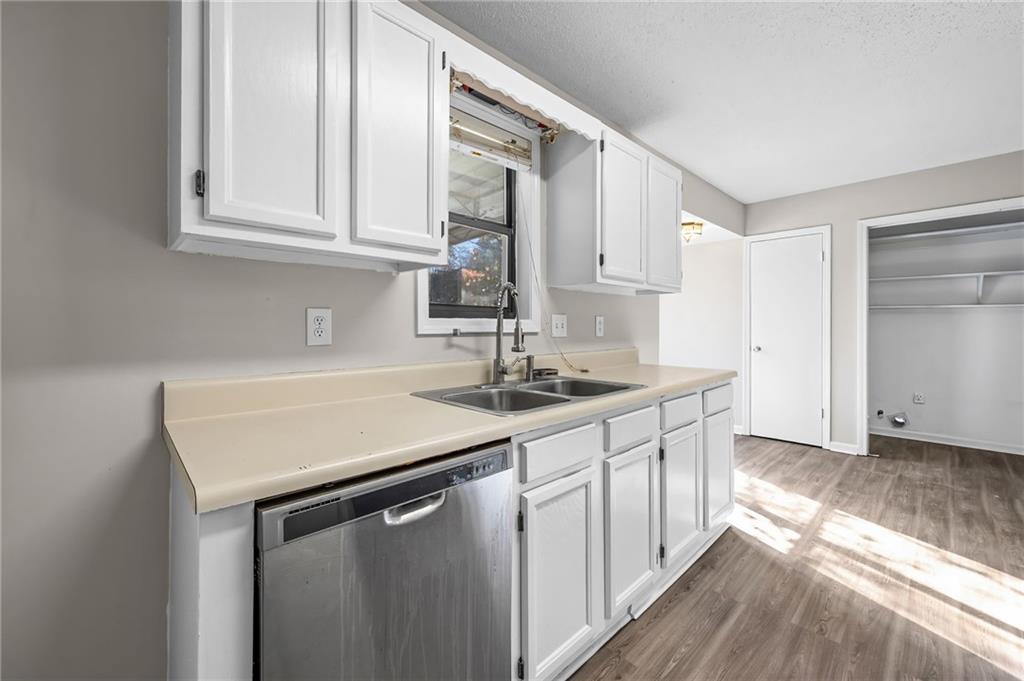 5345 Memorial Lane Southwest Powder Springs, GA 30127 - Photo 14 of 35 a kitchen with stainless steel appliances granite countertop a sink dishwasher a stove and a refrigerator with wooden floor