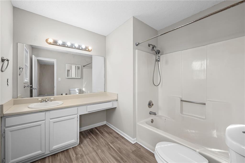 5345 Memorial Lane Southwest Powder Springs, GA 30127 - Photo 29 of 35 a spacious bathroom with a granite countertop sink toilet a large mirror a bathtub and shower