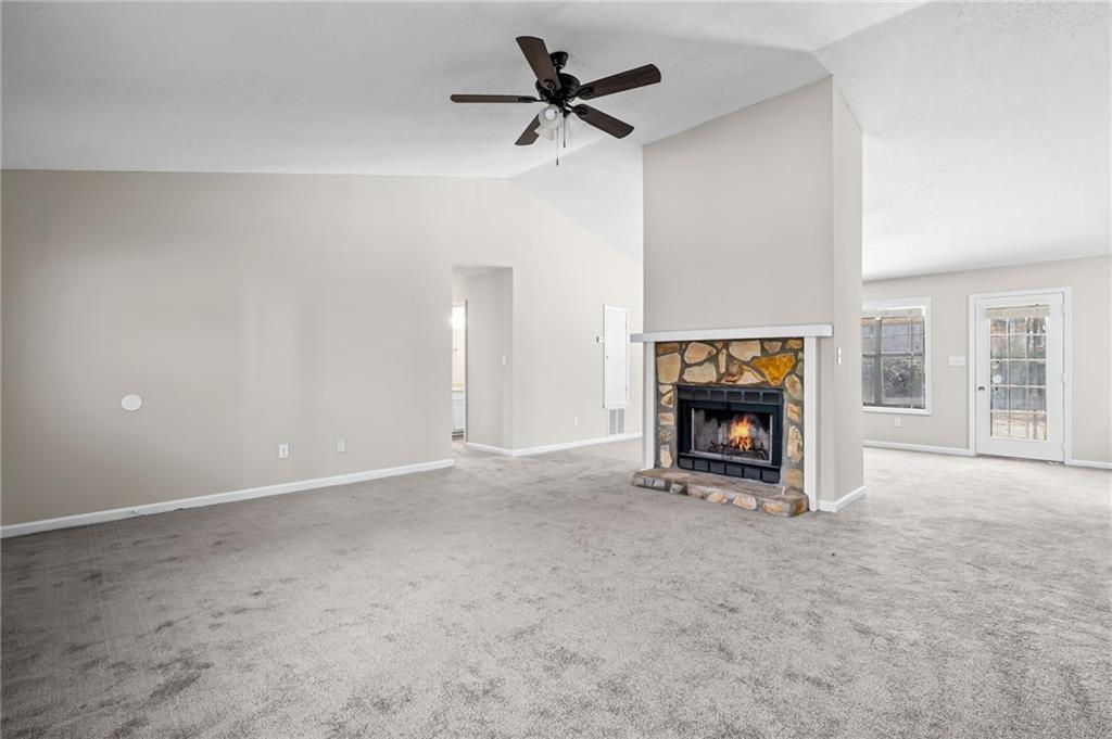 5345 Memorial Lane Southwest Powder Springs, GA 30127 - Photo 6 of 35 an empty room with a fireplace and a chandelier