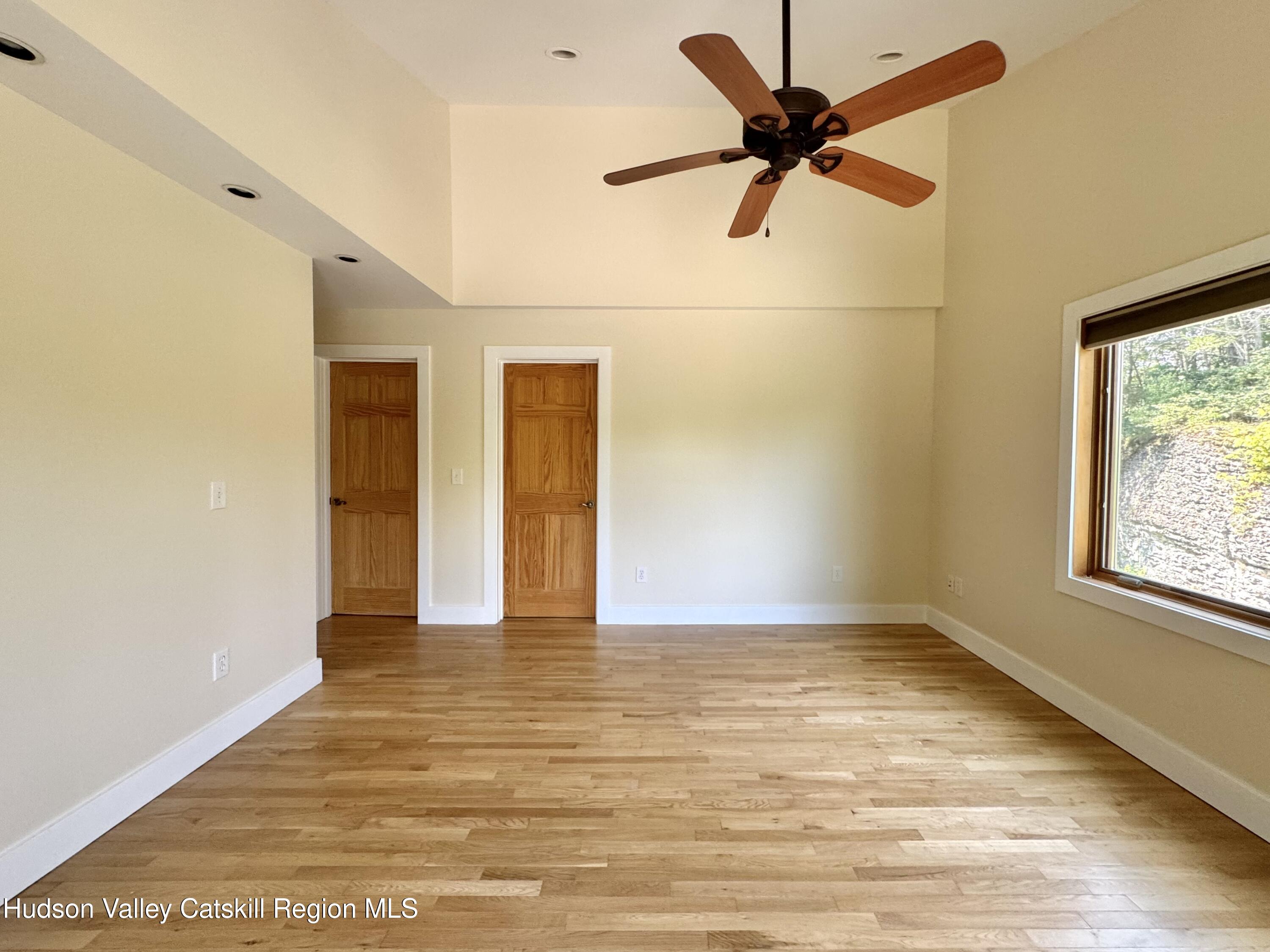 86 Paul Horn Road Catskill, NY 12414 - Photo 17 of 41 a view of an empty room with window and a ceiling fan
