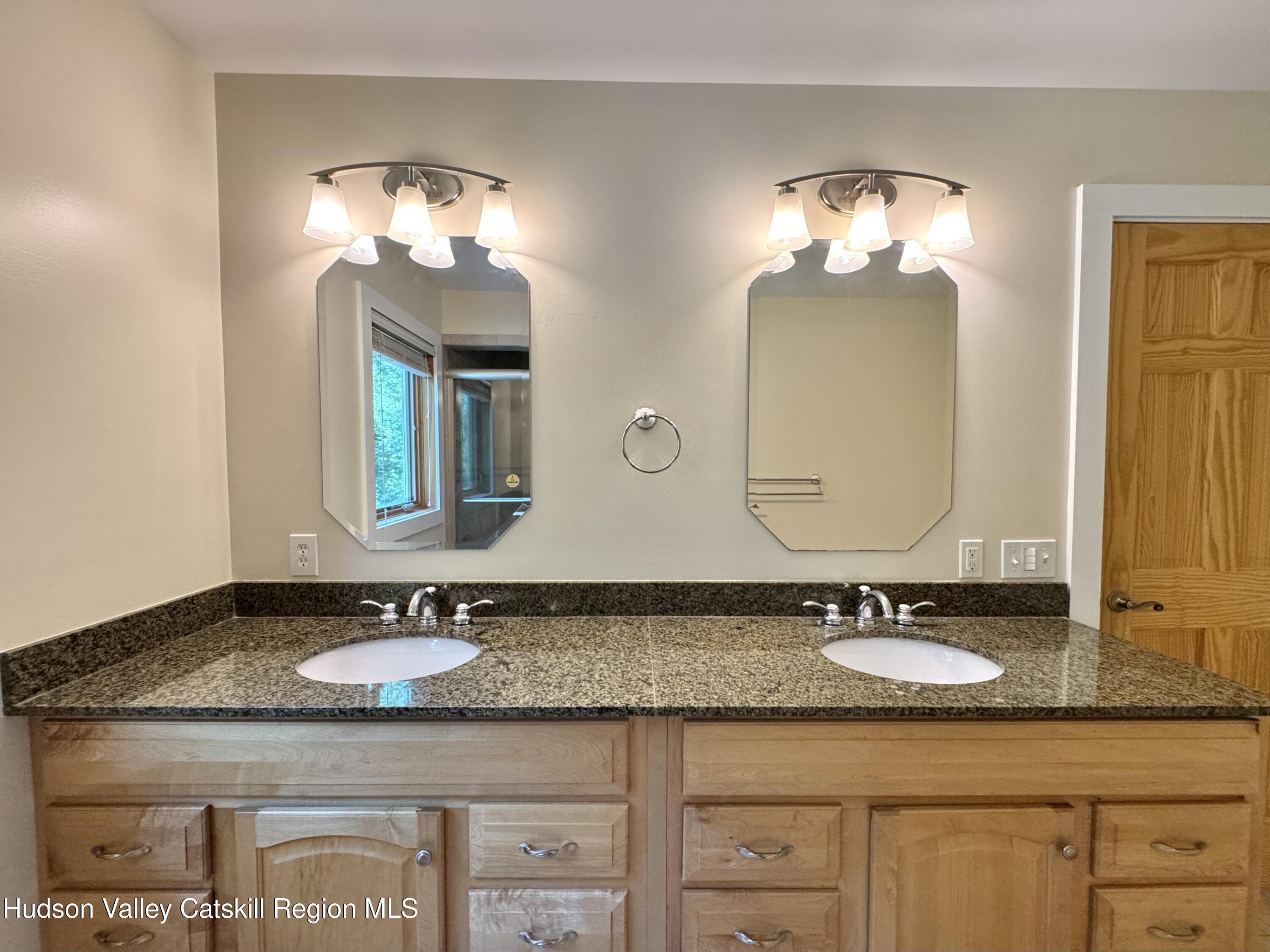 86 Paul Horn Road Catskill, NY 12414 - Photo 18 of 41 a bathroom with a granite countertop double vanity sinks and a mirror
