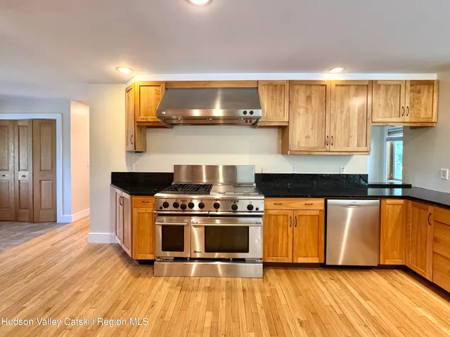 a view of kitchen with stainless steel appliances granite countertop cabinets and a refrigerator