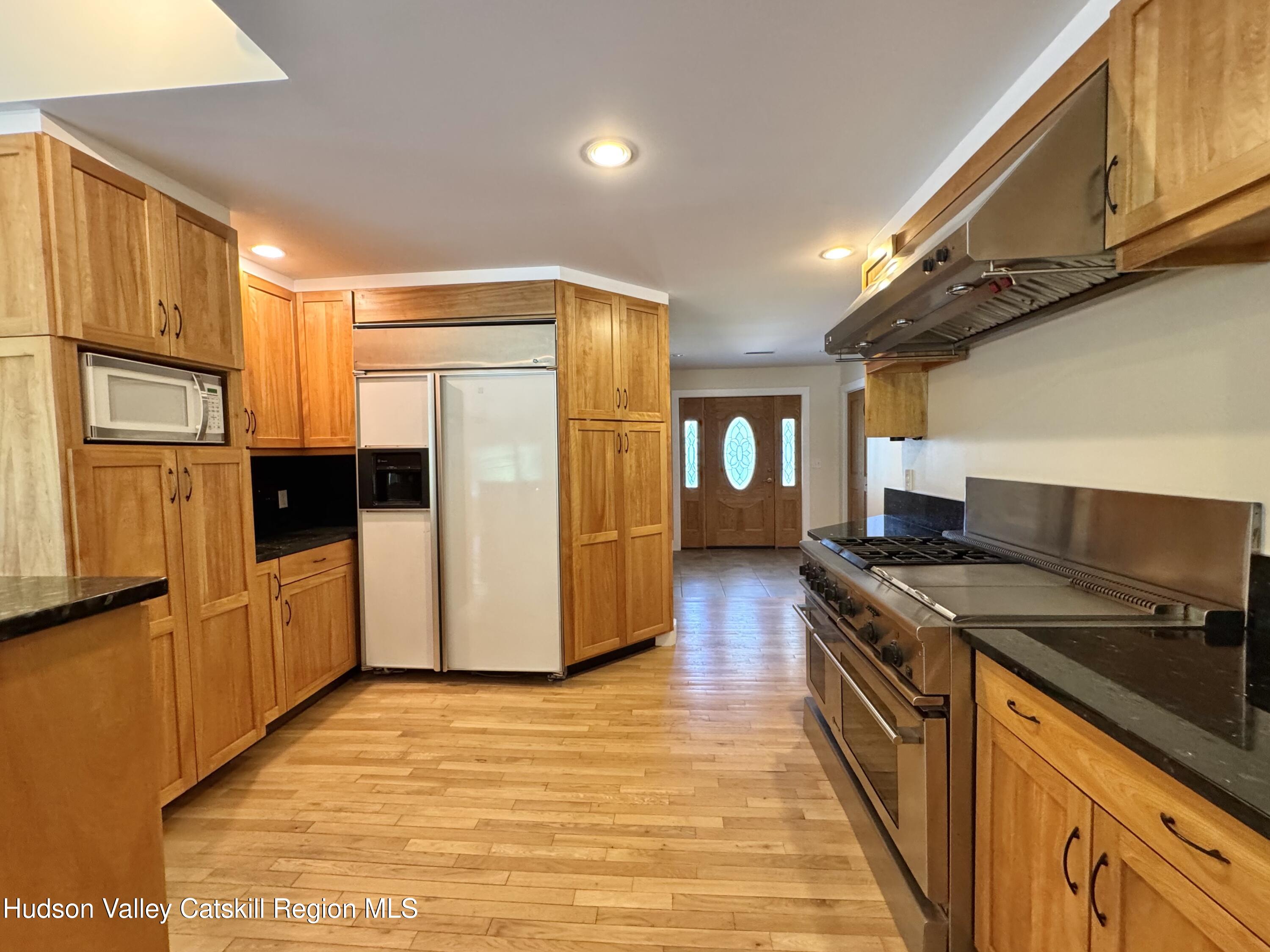 86 Paul Horn Road Catskill, NY 12414 - Photo 6 of 41 a kitchen with stainless steel appliances granite countertop a refrigerator a stove and a wooden floors