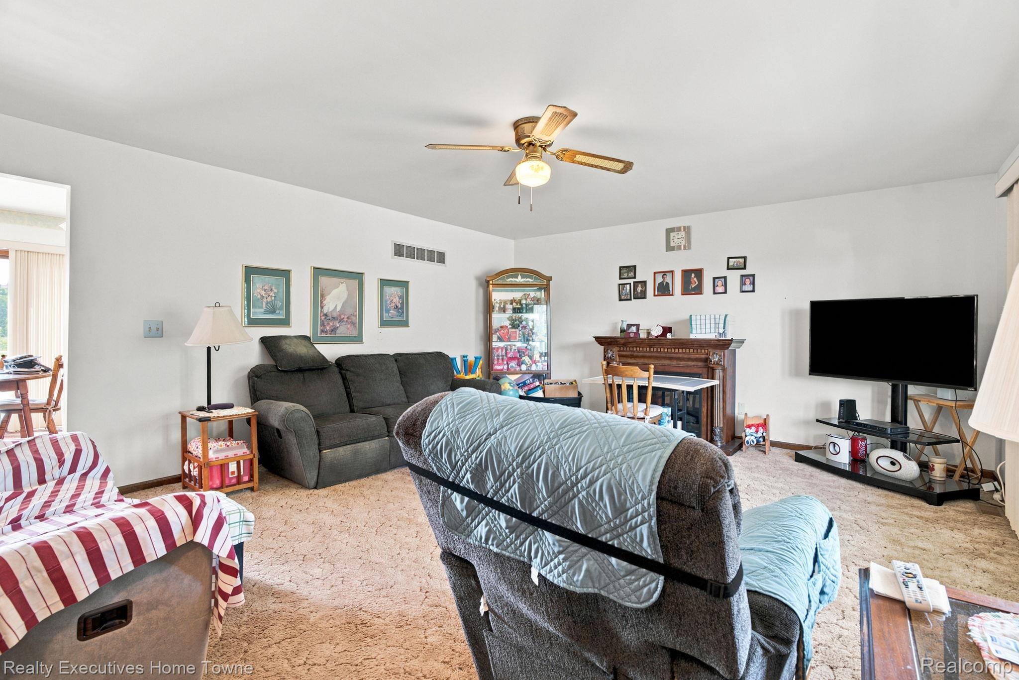 959 Braidwood Road Memphis, MI 48041 - Photo 15 of 58 Living area featuring a ceiling fan with light fixture, white walls, and carpeted flooring