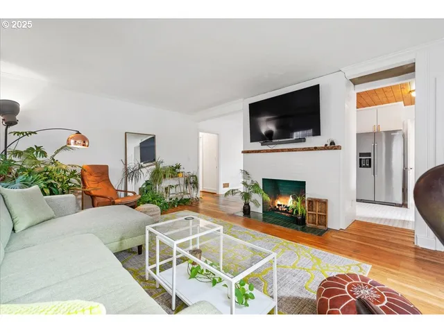 a living room with furniture a flat screen tv and a fireplace