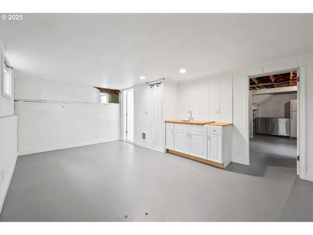 a view of a kitchen with a sink and a refrigerator