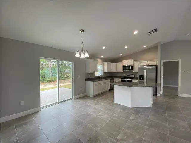 a large kitchen with a large counter top appliances and cabinets