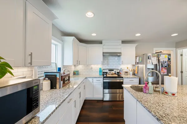 a kitchen with stainless steel appliances granite countertop a sink stove and refrigerator