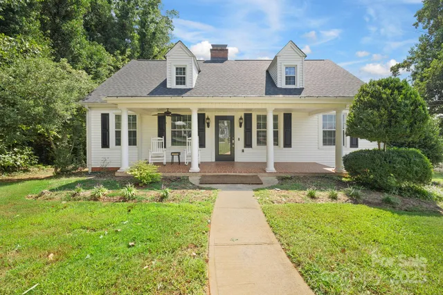 a front view of a house with a yard and potted plants