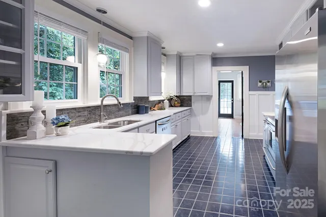 a large kitchen with kitchen island granite countertop a sink a counter top space and stainless steel appliances