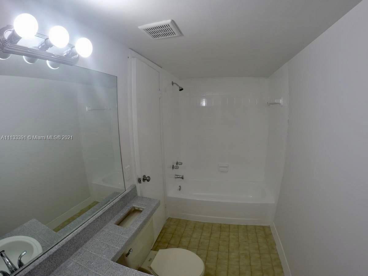 11780 Southwest 18th Street, Unit 2292 Miami, FL 33175 - Photo 9 of 10 a bathroom with a tub shower sink vanity and a toilet