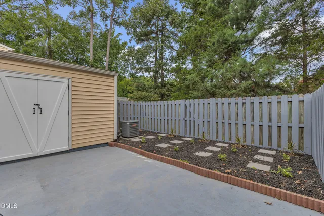 a view of a backyard with a small cabin and wooden fence