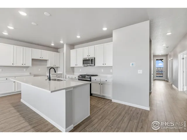 a kitchen with a sink cabinets and wooden floor