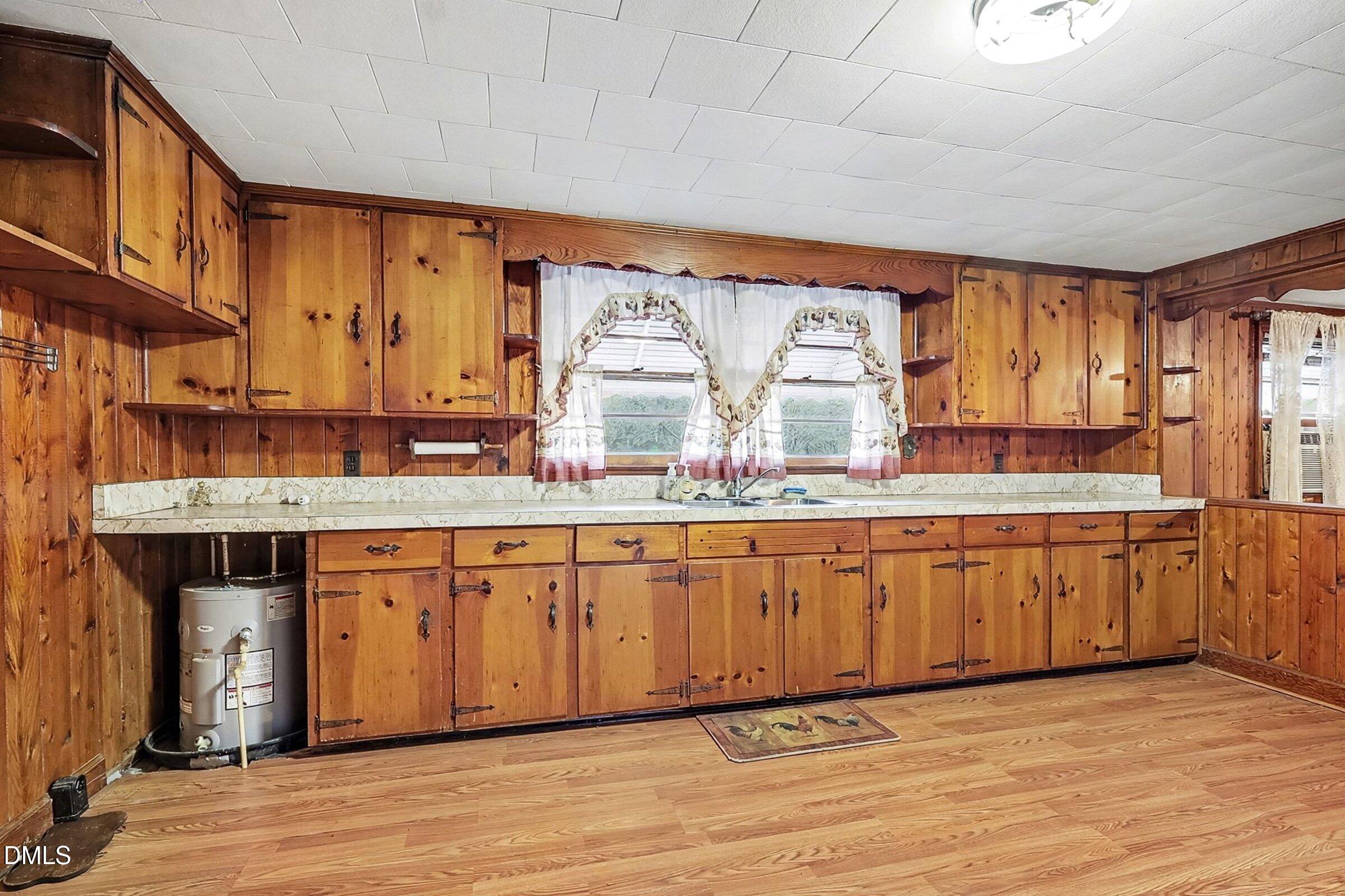 1249 Fann School Road Salemburg, NC 28385 - Photo 9 of 42 a large kitchen with granite countertop a sink cabinets and wooden floor