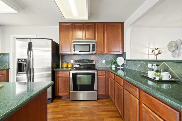 a kitchen with stainless steel appliances granite countertop a sink stove and refrigerator