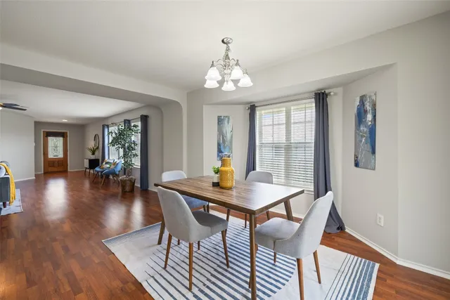 a view of a dining room with furniture wooden floor and chandelier